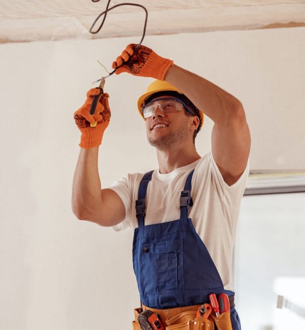 cheerful-electrician-repairing-electric-cable-on-ceiling.jpg